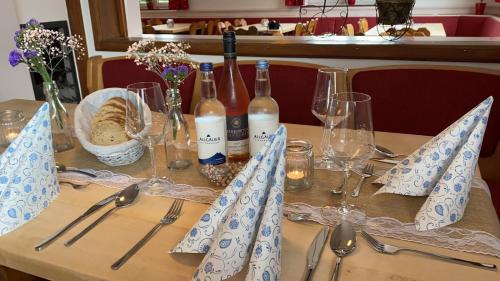 - une table avec des bouteilles de vin et des verres dans l'établissement Wertacher Hof, à Oy-Mittelberg