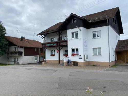 a white building with a black roof on a street at Wertacher Hof in Oy-Mittelberg