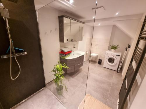a bathroom with a sink and a washing machine at SAV Ferienwohnung in Erfurt