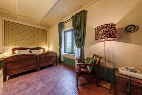 a bedroom with a bed and a chair and a lamp at Agriturismo La Fontaccia in Rufina
