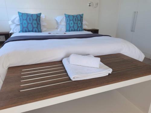 a bed with two towels on top of it at The Paralian Exclusive Guest House in East London