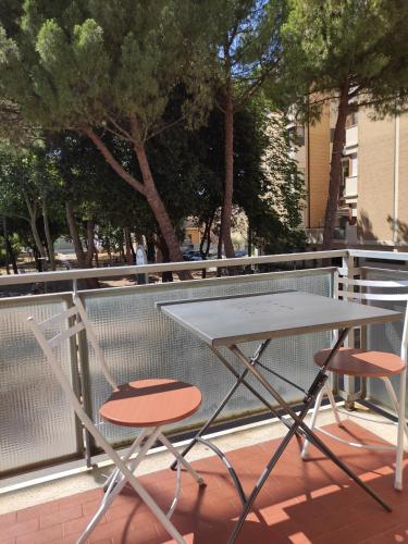 佩薩羅的住宿－Rossetto e cocciolato - Stanza indipendente con bagno privato a Pesaro，阳台配有一张桌子和两把椅子