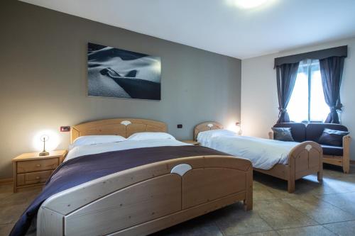 a bedroom with two beds and a chair at Marangon Apartments in Sùtrio