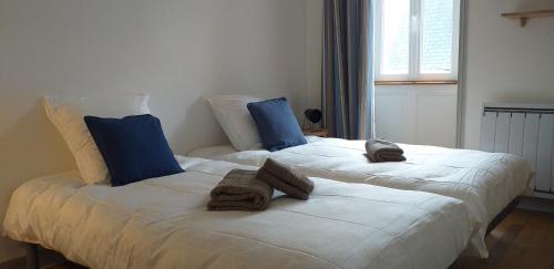 2 camas con toallas encima de ellas en un dormitorio en AU 13 : FENETRES SUR ARROMANCHES en Arromanches-les-Bains
