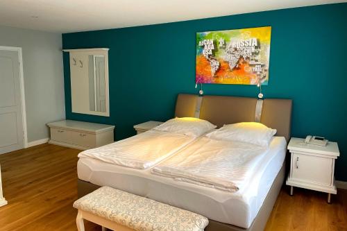 1 dormitorio con 1 cama grande y pared azul en Seehotel Louise, en Gransee