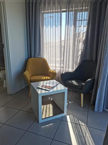 a living room with two chairs and a table at The Paralian Exclusive Guest House in East London