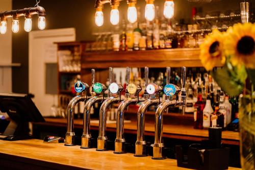 un bar con una fila de copas de vino en una barra en The Cricketers Arms en Stansted Mountfitchet