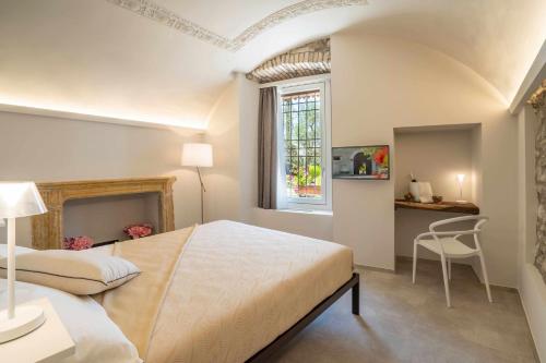 a bedroom with a bed and a desk and a window at Palazzo Trevignane appartamento La Saletta Verde in San Felice del Benaco