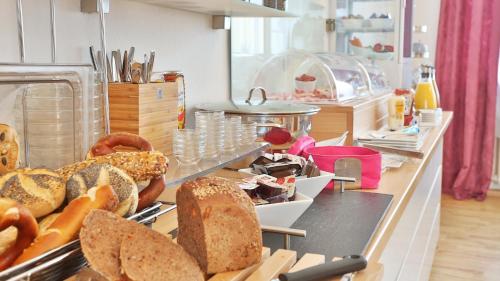 a counter with bread and other food items on it at Hotel Prinz Carl - Apartments mit Klimaanlage in Neckarsulm