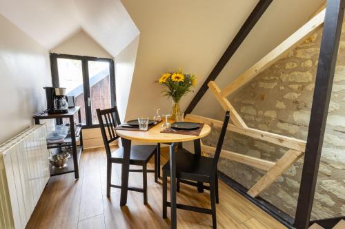 une salle à manger avec une table et des chaises et un escalier dans l'établissement Kinabalu - Domaine Tropical, à Saint-Aignan