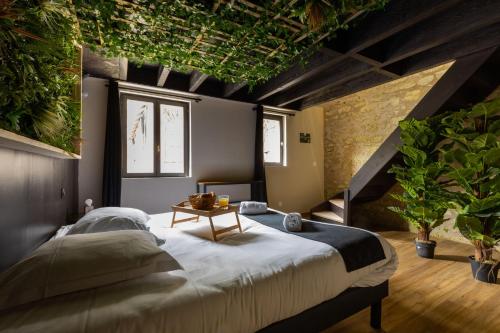 1 dormitorio con 1 cama grande con plantas en el techo en Kinabalu - Domaine Tropical, en Saint-Aignan