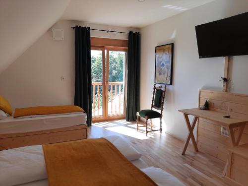 1 dormitorio con 2 camas, escritorio y ventana en Rooms & Wine Lilek en Šentilj