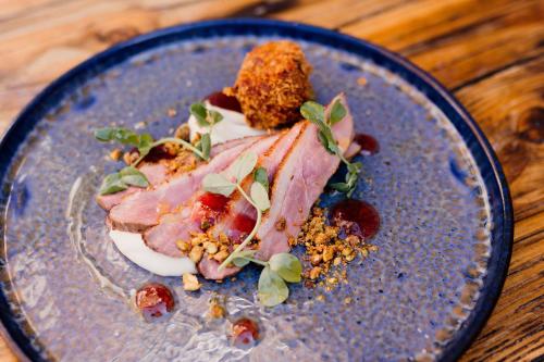 a blue plate with food on a wooden table at The Cricketers Arms in Stansted Mountfitchet