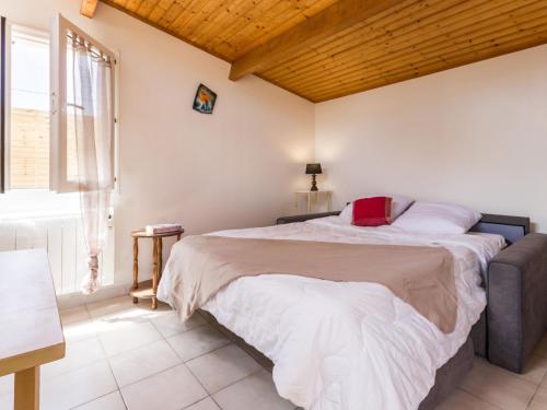 ein Schlafzimmer mit einem Bett mit einem roten Kissen darauf in der Unterkunft Gîte Saint-Brevin-les-Pins, 1 pièce, 2 personnes - FR-1-306-907 in Saint-Brevin-les-Pins