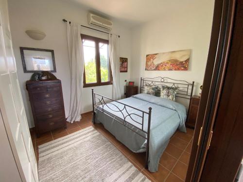een slaapkamer met een bed, een dressoir en een raam bij Villetta a Corigliano D'Otranto in Melpignano