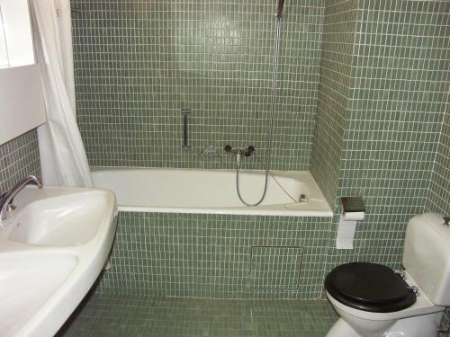 アンゼールにあるApartment Mars 404-406の緑のタイル張りのバスルーム(トイレ、バスタブ付)