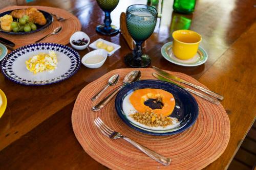 a wooden table topped with plates of food and drinks at Casa Ka in Maresias