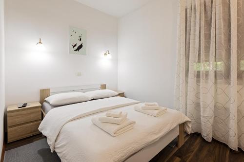 two beds in a room with two towels on them at Cozy House Ania in Plitvička Jezera