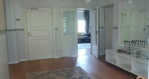 uma sala de estar com portas brancas e piso de madeira em Vääpeli em Hämeenlinna