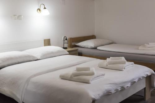 two beds in a room with white towels on them at Cozy House Ania in Plitvička Jezera
