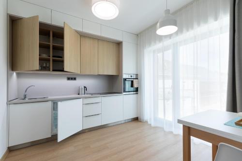 a kitchen with white cabinets and a large window at RASL House in Luka nad Jihlavou