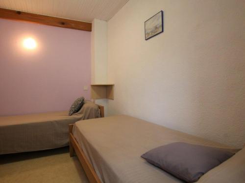 een kleine kamer met 2 bedden en een muur bij Gîte Chavaniac-Lafayette, 3 pièces, 4 personnes - FR-1-582-175 in Chavaniac-Lafayette