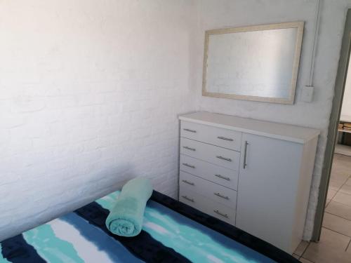 una camera da letto con cassettiera e specchio di Die Waenhuis a Arniston