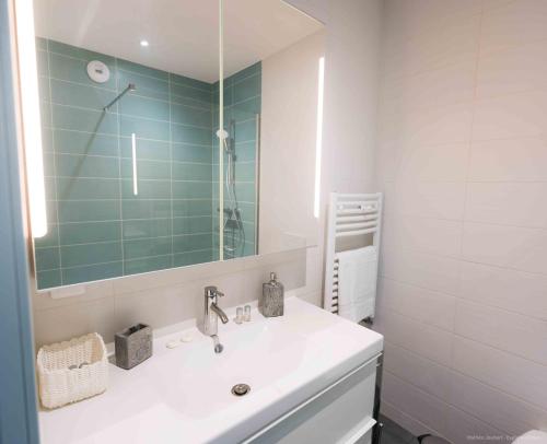 a bathroom with a white sink and a mirror at Chambres d'hôtes du Bistrot d'ici in Saint-Saturnin
