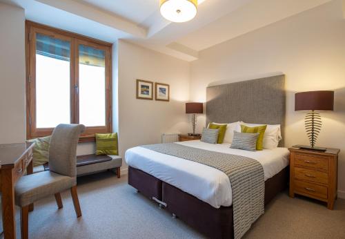 a bedroom with a bed and a desk and a chair at Inverness City Suites in Inverness