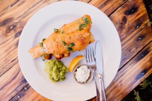 a plate of food with fish and broccoli on a table at The Cricketers Arms in Stansted Mountfitchet