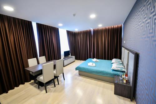 - une chambre avec un lit bleu, une table et des chaises dans l'établissement La Casa Apartments, à Banja Luka