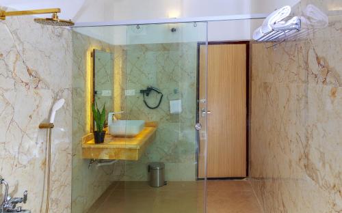 a bathroom with a sink and a shower with a mirror at HOTEL ROYAL GRANDE in Vellore