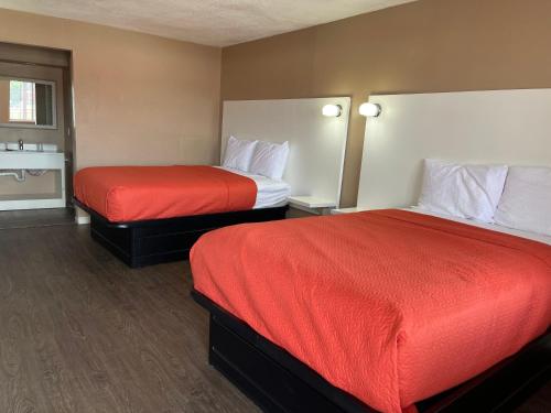a hotel room with two beds with red sheets at Hotel Eastin Atchison in Atchison