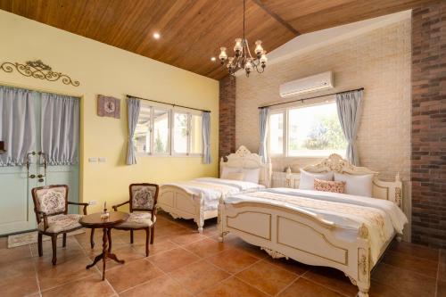 1 dormitorio con 2 camas, mesa y sillas en Brulee's Done en Dongshan