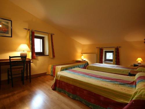 a hotel room with two beds and a desk at Gîte Villeneuve-d'Allier, 4 pièces, 6 personnes - FR-1-582-208 in Villeneuve-dʼAllier