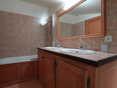 a bathroom with a sink and a mirror and a tub at Gîte Villeneuve-d'Allier, 4 pièces, 6 personnes - FR-1-582-208 in Villeneuve-dʼAllier