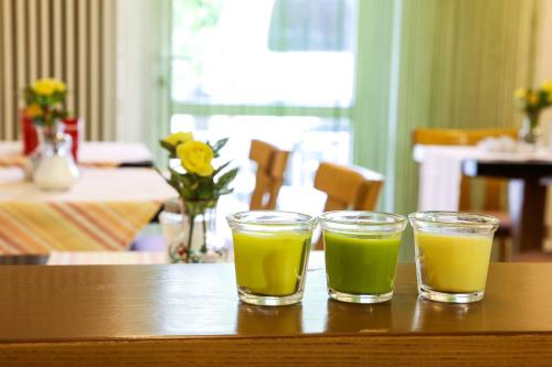 dos vasos de jugo sentados en una mesa en Hotel Reutiner Hof, en Lindau
