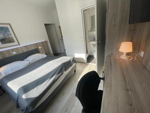 a bedroom with a bed and a desk with a lamp at Pension Der Kretaner in Berlin