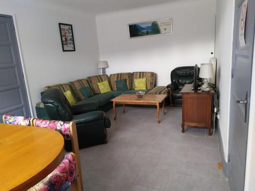 a living room with a couch and a table at Gîte convivial avec 3 chambres, proche du patrimoine historique, cour et équipements inclus - FR-1-589-38 in Aouze