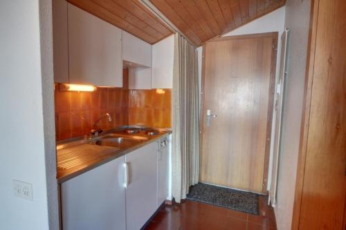 アンゼールにあるApartment Mercure 501の白いキャビネット、シンク、ドア付きのキッチン