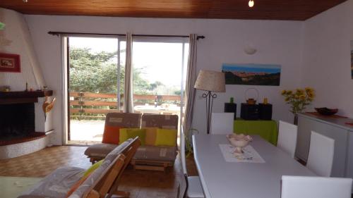 un salon avec une table et des chaises et un salon dans l'établissement Spacieuse villa T4, Narbonne Plage, à Narbonne-Plage
