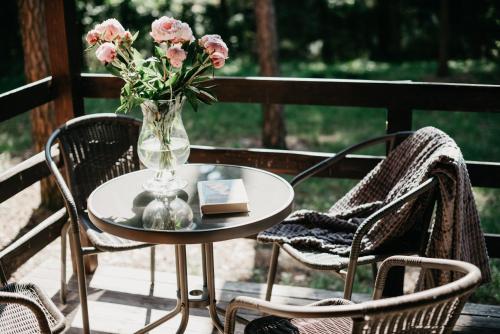a vase of flowers sitting on a table with two chairs at Domki-Temar Kompleks Wypoczynkowy in Dąbie