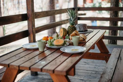 a wooden table with a plate of food on it at Domki-Temar Kompleks Wypoczynkowy in Dąbie