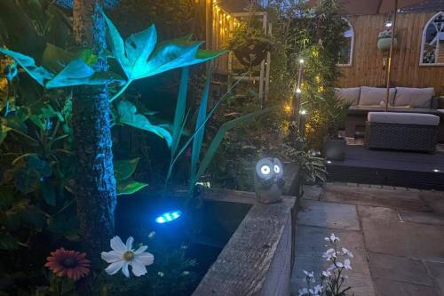a fish tank in a garden at night at Secret Gem 1 Bed Garden Flat Private Luxury Hot Tub in Bournemouth