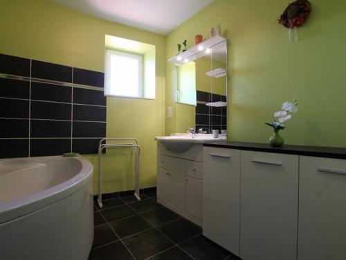 a bathroom with a tub and a sink and a mirror at Gîte Rauret, 4 pièces, 7 personnes - FR-1-582-203 in Rauret