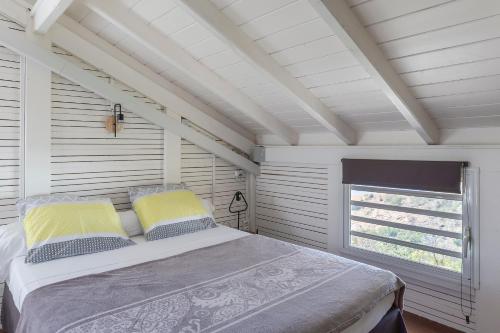 a bedroom with a bed and a window at Le Palma Christi in Le Carbet