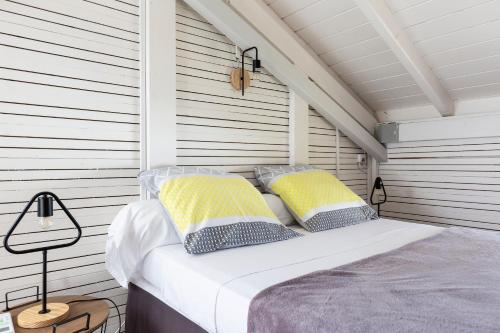 a bed with yellow and white pillows in a room at Le Palma Christi in Le Carbet
