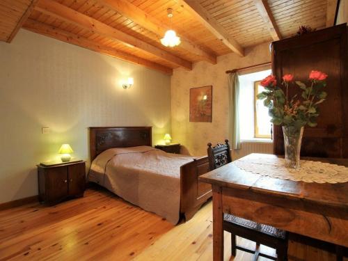 um quarto com uma cama e uma mesa com flores em Gîte Saint-Cirgues, 4 pièces, 6 personnes - FR-1-582-56 em Saint-Cirgues