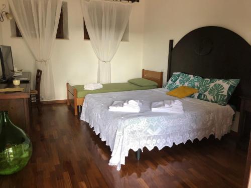 a bedroom with a large bed with white sheets at Agriturismo DonnoMarco in Simeri