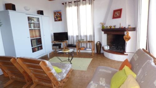 un salon avec un canapé et une cheminée dans l'établissement Spacieuse villa T4, Narbonne Plage, à Narbonne-Plage